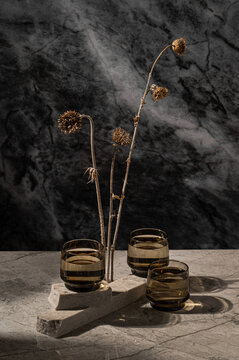 Still life with different textures of marble,  and dried plant.