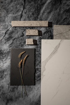 Flatlay with different textures of grey marble, stone and dried grass.