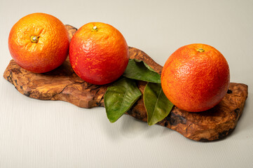 Sicilian sweet juicy yellow and red blood oranges with green leaves close-up