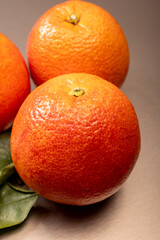 Sicilian sweet juicy yellow and red blood oranges with green leaves close-up
