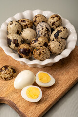 Fresh small spotted partridge or quail bird eggs uncooked and cooked