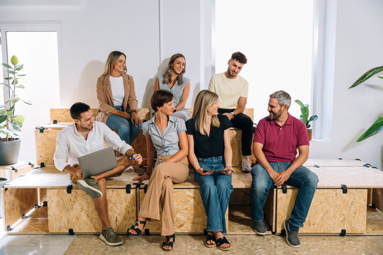 Coworkers meeting and sharing ideas in modern workspace