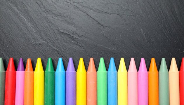 Colorful crayons in a row against a dark slate background