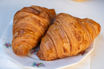 Fresh baked two buttered croissants served in restaurant for continental or French breakfast on board
