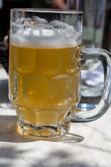 Belgian beer in glass in old brewery in Bruges, light or dark, tasty beverage, lunch with beer, tourist destination, Flanders, Belgium
