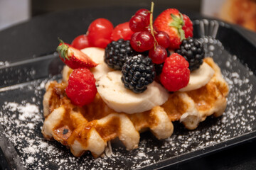 Baked belgian sugar waffles with various toppings, delicious sweet street food in Bruges, Flanders, Belgium