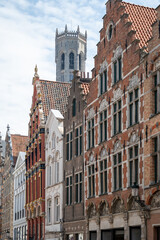 Obraz premium Medieval houses facades and rooftops and city tower with bells in the centre of Bruges, Flanders