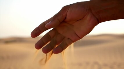 Time slipping through fingers concept showing hand letting sand run out, desert scene - Powered by Adobe
