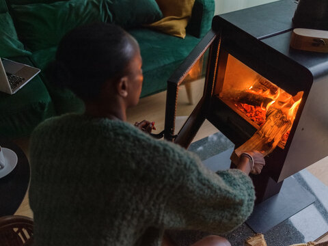 Woman putting log into chiminea