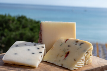 Italian provolone cheese made with fresh rocket salad, black pepper, olives, wine, Sicilian cheese, Palermo food and sea view on Mondello beach nea Palermo, Sicily