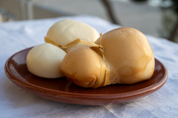 Italian semi hard handmade white and smoked scamorza cheese, from cow milk from Apulia or Calabria...