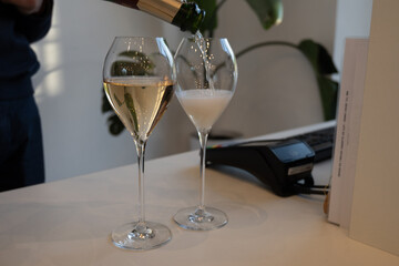 Pouring in glass of white sparkling wine brut, grand reserve, champagne in Ay-Champagne old grand cru wine making village in Vallee de la Marne, Champagne, France