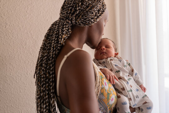 Loving mom kissing baby forehead