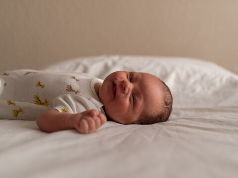 Happy newborn lying on bed