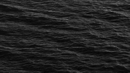 A captivating black and white image of sea waves in motion, where the dynamic flow of the water creates a powerful visual, showcasing the raw energy and beauty of the ocean's movement.
