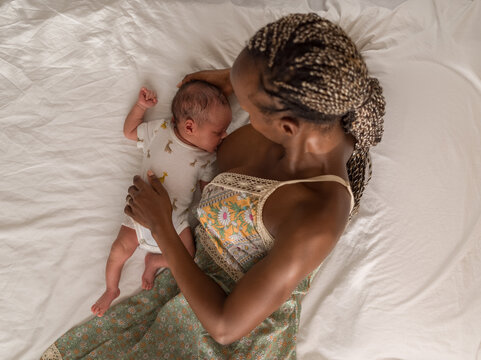 Young mother breastfeeding baby in bed