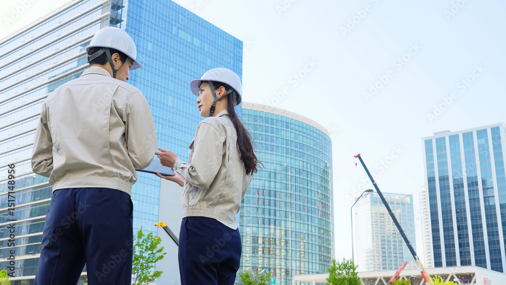Aufkleber 建設現場でタブレットを見ながら打ち合わせする男女エンジニアのグループ