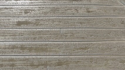 Fototapeta premium A rice field being prepared for planting, with straight irrigation channels and wet, freshly plowed soil creating an intricate grid layout, showcasing the agricultural process in action. Drone view. 