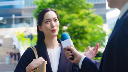 街頭インタビューを受ける女性ビジネスパーソン
