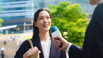 街頭インタビューを受ける女性ビジネスパーソン
