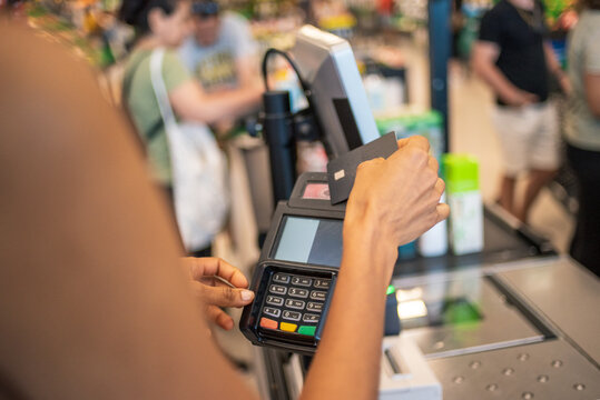 Anonymous hand paying with credit card at supermarket