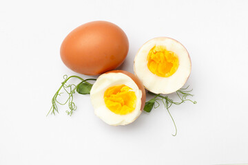 Hard boiled eggs and microgreens on white background, top view