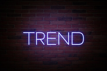 Obraz premium Neon sign with word Trend on brick wall