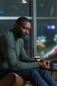 Pensive Man Sitting by the Window at Night