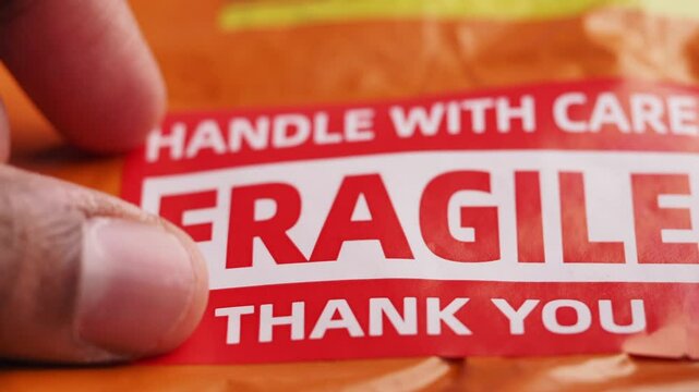 putting fragile label on a delivery packet 