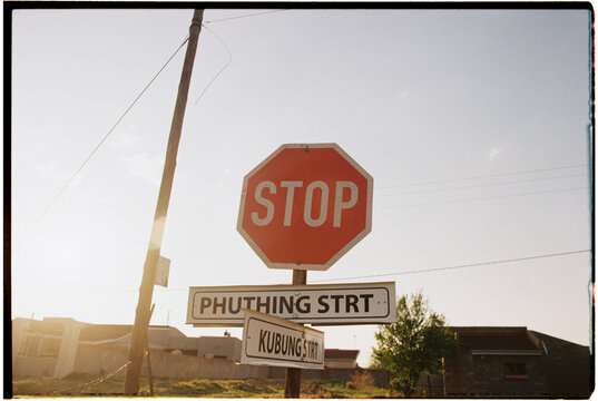 Backlit photo of stop sign with street names 