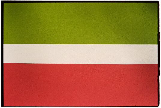 Strip of white paint between green and red paint on a wall