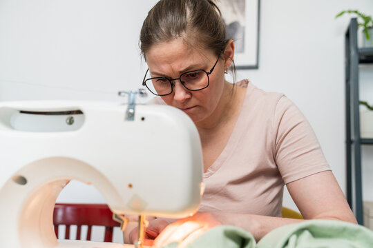 Focused woman using a sewing machine