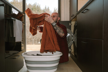 Man doing laundry at home while managing daily chores