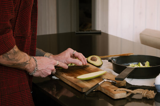 A man is focused on preparing fresh ingredients in his modern kitchen