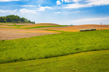 Scenic Farm Field with Rolled Hay and American Flag