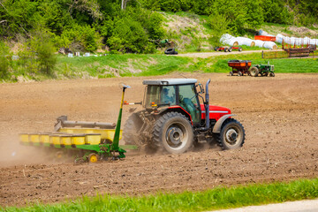 Tractor Fertilizing and Planting Crops on Farm Field