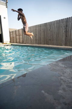 Boy jumping into pool