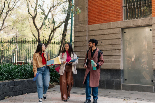 Smiling university students walking on campus.