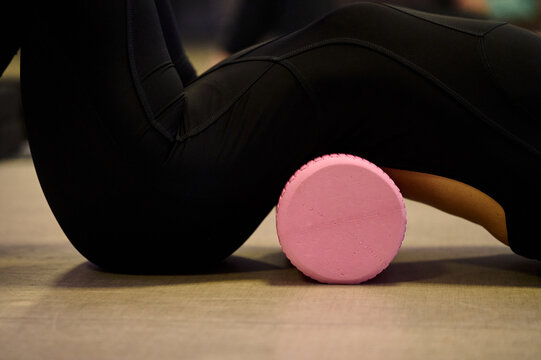 Deep stretch with foam roller in yoga studio