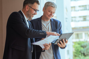 A two man businessman Reviewing Documents and Digital Tablet in Modern Office