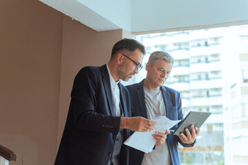 A two man businessman Reviewing Documents and Digital Tablet in Modern Office