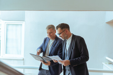 A two man businessman Reviewing Documents and Digital Tablet in Modern Office