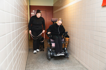 Woman in Electric Wheelchair with Service Dog in Hallway