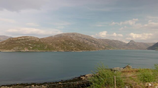 Panning shot of the beautiful Scottish Highlands and loch near the Kylesku bridge