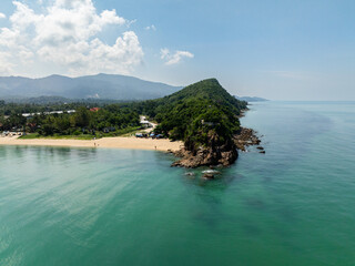Serene white sand beach surrounded by lush greenery and clear turquoise waters under a sunny sky. Koh Samui, Thailand.
