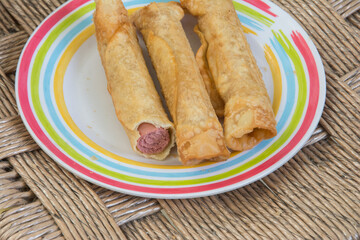 Fried spring rolls with sausage in a plate on the table