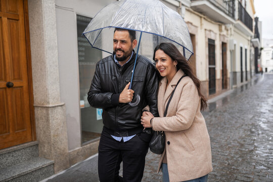 Couple walking in the rain under an umbrella