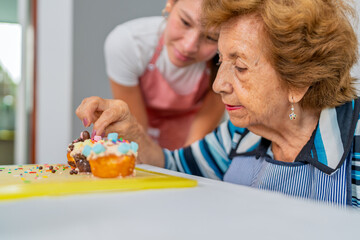 Grandmother teaching granddaughter secret baking recipes in the kitchen