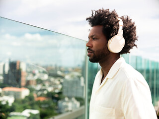 Man Wearing Headphones with Urban Background and Reflective Glass