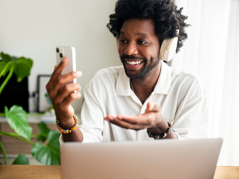 Smiling Person Using Smartphone During Video Call at Home